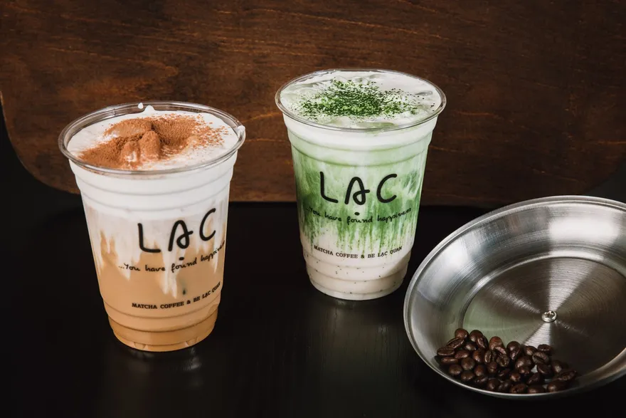 Iced Vietnamese coffee and hand-whisked matcha served side by side in Lạc Coffee cups